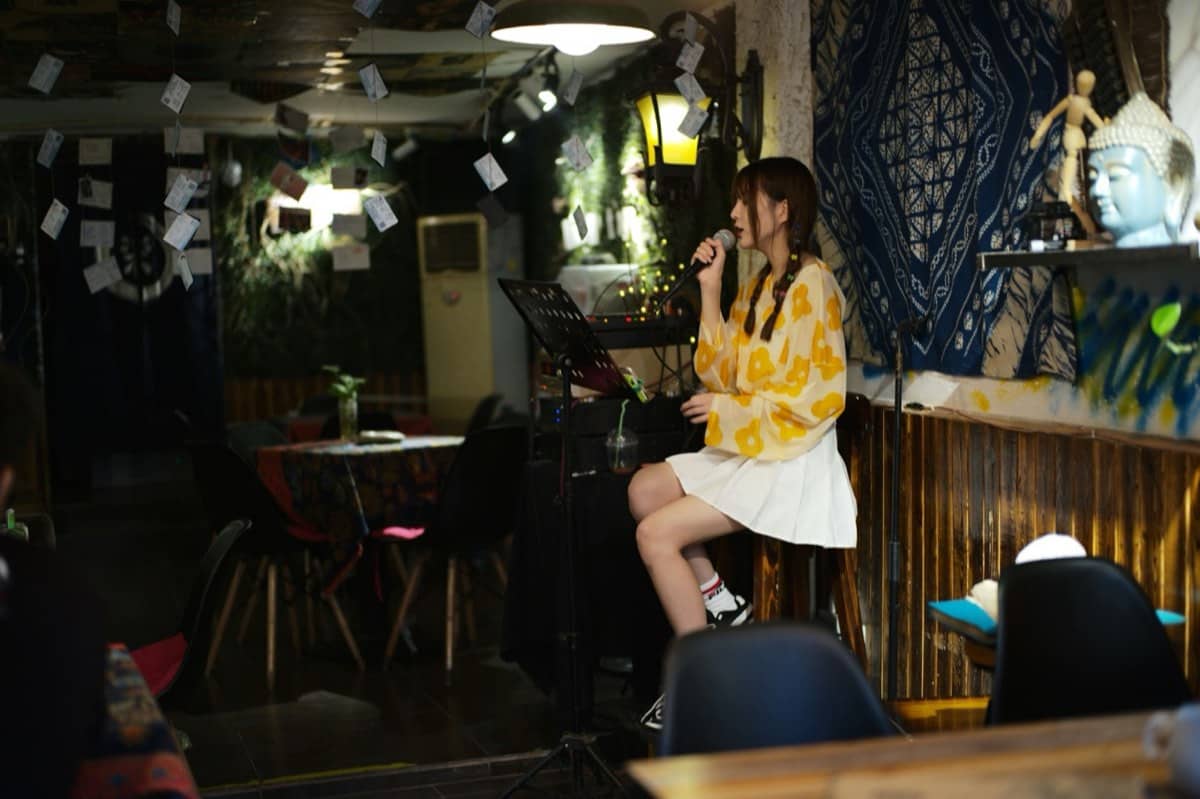 Singer on a stool at a café open mic