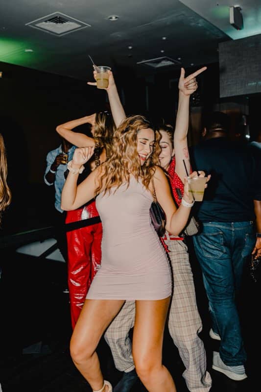 Friends dancing with drinks raised