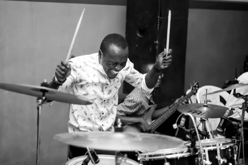 Drummer mid-fill, grinning