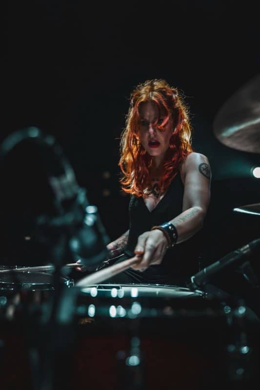Drummer mid-song under stage light