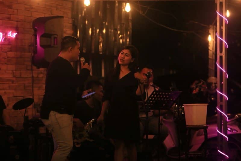Duo singing under pink neon